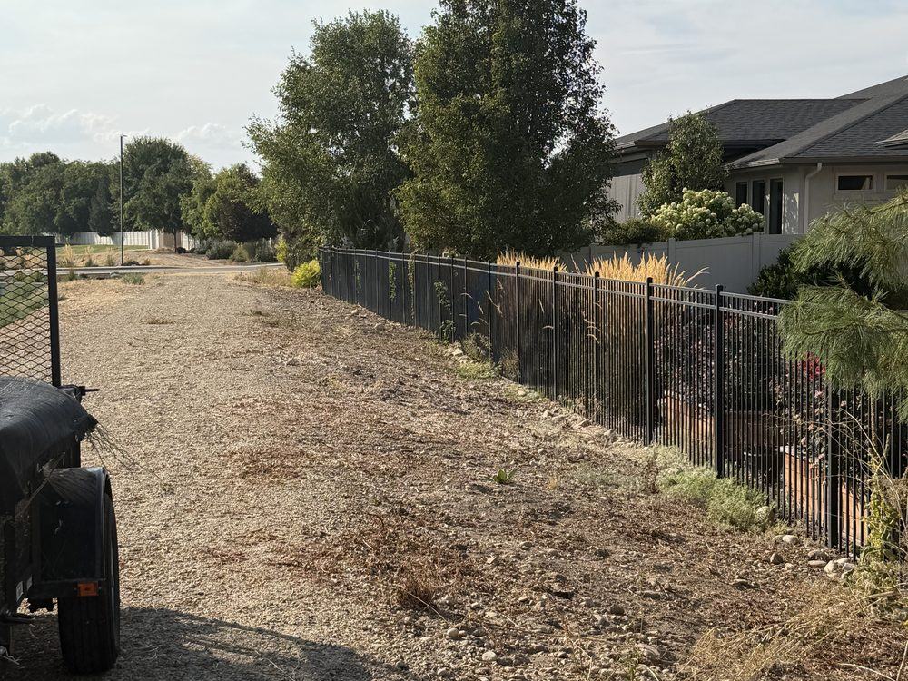 The same Meridian fence line cleared back to bare gravel after HaulWorks removed the weeds and brush