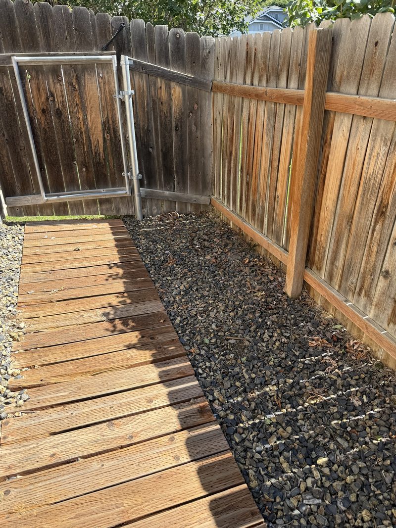 The same Meridian side yard corner cleared back to bare gravel